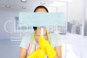 Composite image of young woman hiding behind mop