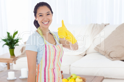 Composite image of woman in cleaning clothes giving thumbs up