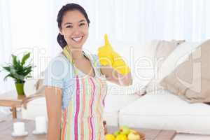 Composite image of woman in cleaning clothes giving thumbs up