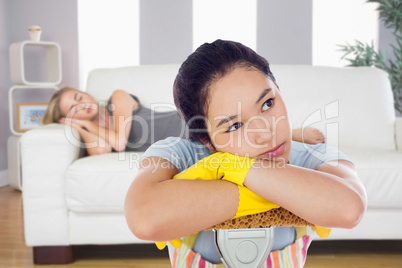 Composite image of troubled woman leaning on a mop