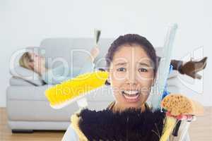 Composite image of very stressed woman with cleaning tools