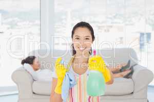 Composite image of cheerful woman holding up spray bottle