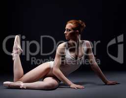 Fascinating red-haired ballerina posing in studio