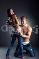 Couple of playful young people undresses at camera