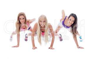 Three charming young sporty girls posing at camera