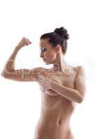 Portrait of nude slender girl looks at her biceps