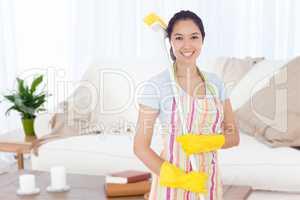 Composite image of smiling woman with a broom on her shoulder