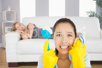 Composite image of distressed woman holding cloth and scrubbing