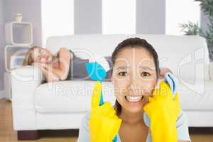 Composite image of distressed woman holding cloth and scrubbing