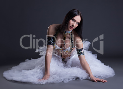 Seductive young belly dancer posing at camera