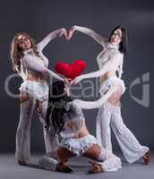 Trio of beautiful go-go dancers posing as cupids