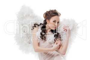 Beautiful girl in angel costume posing at camera