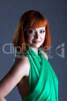 Hot red-haired model posing in green dress