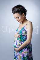 Lovely pregnant woman posing stroking her belly