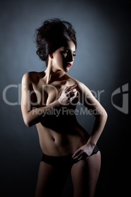 Hot brunette posing topless, covering her breasts