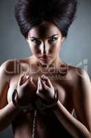 Shot of beautiful nude brunette posing handcuffed