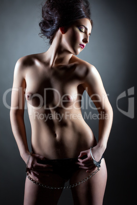 Languid young model posing topless in handcuffs