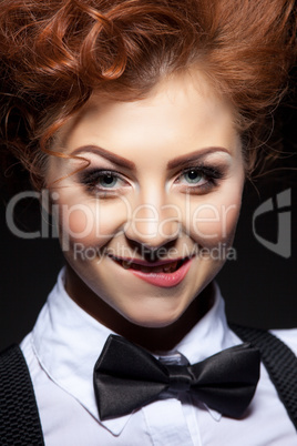 Cute red-haired girl posing coquettishly at camera