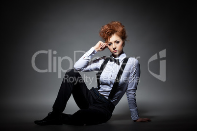 Serious red-haired woman posing in office suit