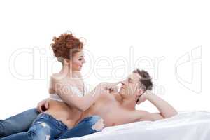 Image of flirting young lovers posing in bed