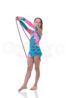 Adorable little gymnast posing with skipping rope