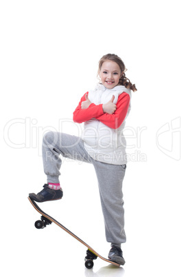 Cheerful little skateboarder posing with thumbs up