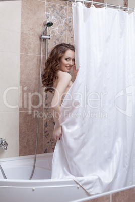 Shy smiling woman posing nude in shower