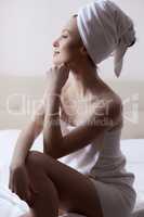 Side view of pensive pretty girl dressed in towel