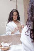 Charming woman looking at her reflection in mirror