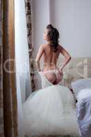Beautiful slim girl takes off her wedding dress