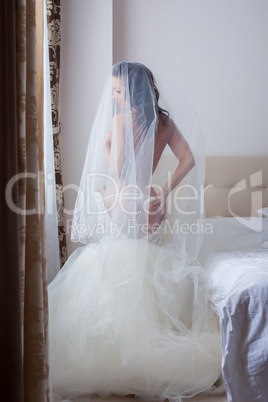 Beautiful seminude bride posing in hotel room