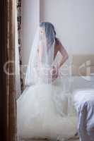 Beautiful seminude bride posing in hotel room