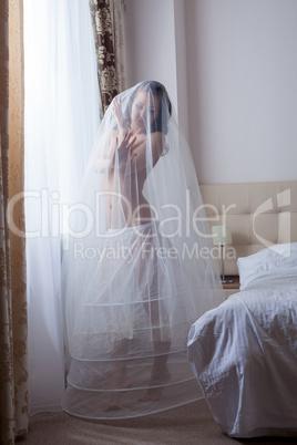 Cute girl posing in wedding petticoat and veil