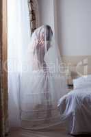 Cute girl posing in wedding petticoat and veil