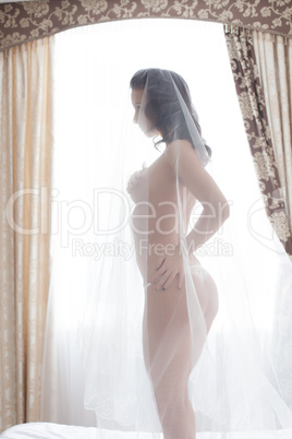 Image of slim bride posing naked in hotel room