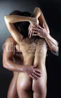 Rear view of muscular naked couple embracing