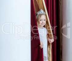 Image of adorable girl posing looking out curtains