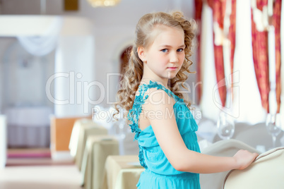 Beautiful curly girl posing in elegant blue dress