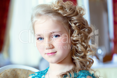 Portrait of little blue-eyed girl with ringlets