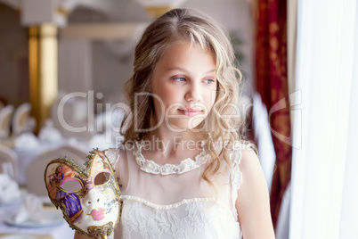 Dreamy little lady posing with carnival mask
