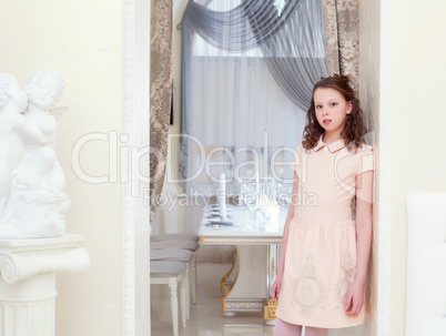 Charming curly girl posing in hotel restaurant