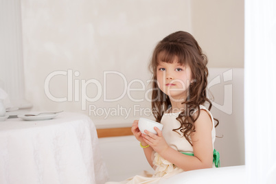 Pretty brown-eyed girl drinking tea in restaurant