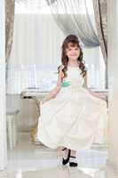 Lovely little girl posing in white elegant dress