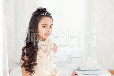Pretty little brunette posing in tiara, close-up