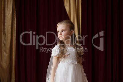 Girlie in white dress posing on curtain backdrop
