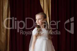 Girlie in white dress posing on curtain backdrop