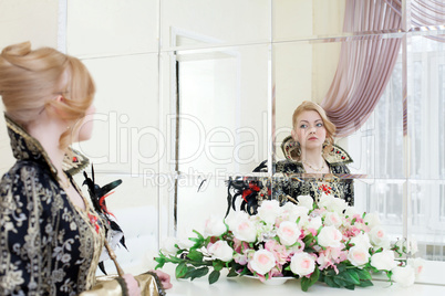 Young actress looking at her reflection in mirror