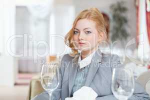 Serious businesswoman posing at table, close-up