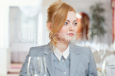 Confident young girl posing at table in restaurant