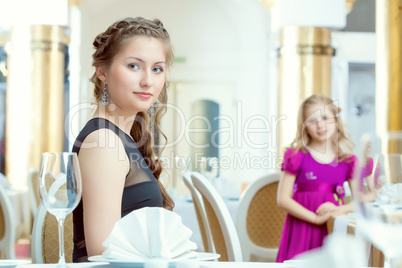 Pretty young sisters posing at restaurant